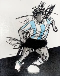 Ilustración estilo stencil de Diego Maradona con camiseta de Argentina en celeste y blanco, conduciendo un balón de fútbol, obra original de Irreverentes.