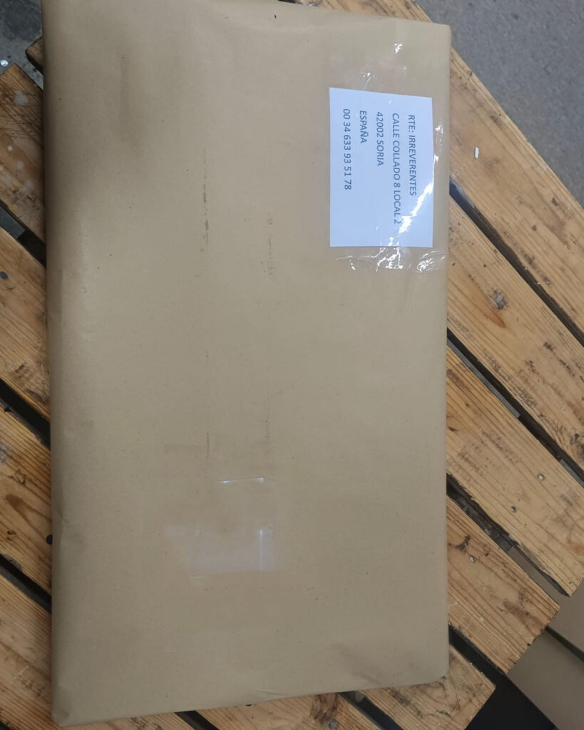 Paquete de cuadro artesanal cuidadosamente embalado en papel kraft listo para envío desde taller artístico.