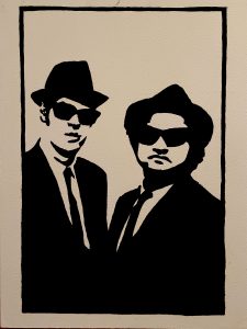 Silueta en blanco y negro de los Blues Brothers con traje, sombrero y gafas de sol