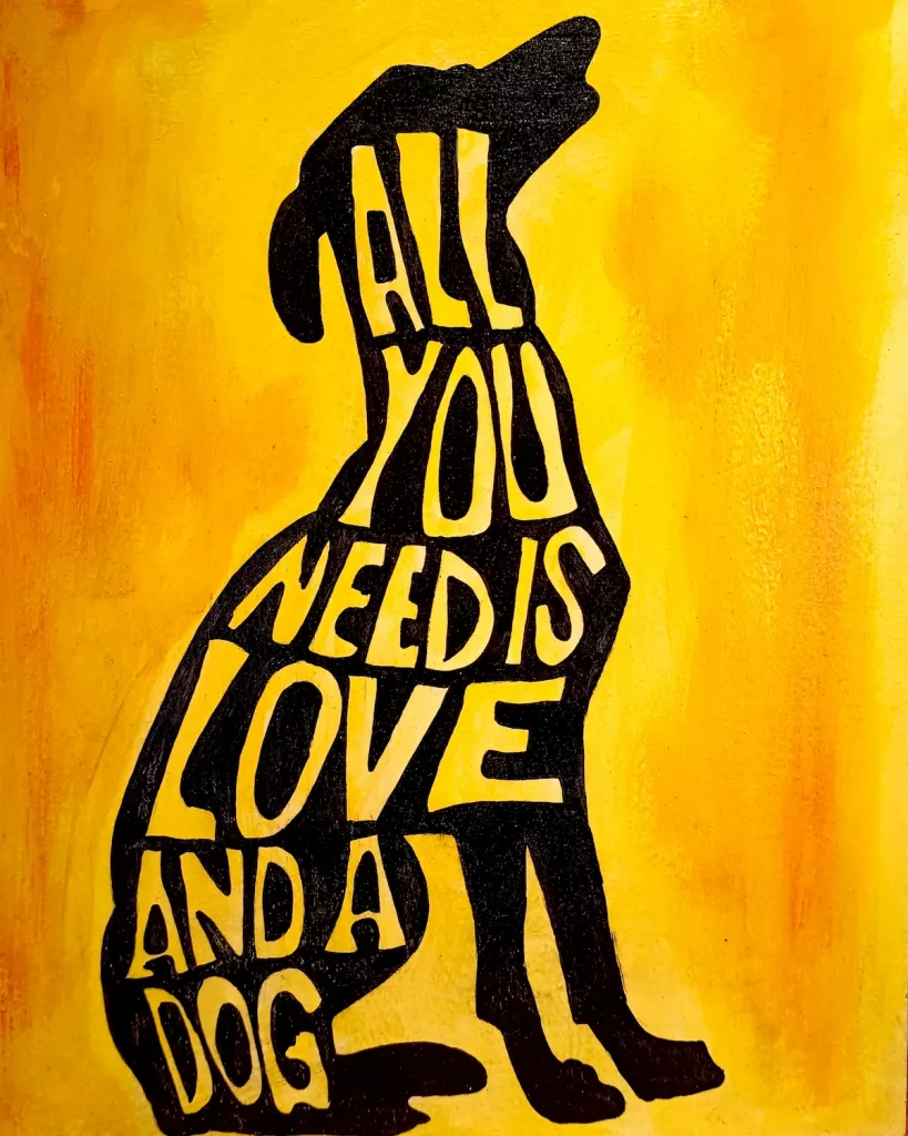 Pintura acrílica de la silueta de un perro en negro con el texto "All You Need Is Love and a Dog" integrado en la figura, sobre fondo amarillo, pintada a mano sobre tabla de DM.