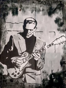 Cuadro pintado a mano de Frankenstein tocando una guitarra eléctrica, estilo stencil en blanco y negro sobre tabla