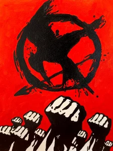 Ilustración del símbolo del sinsajo de Los Juegos del Hambre sobre fondo rojo con puños alzados de protesta.