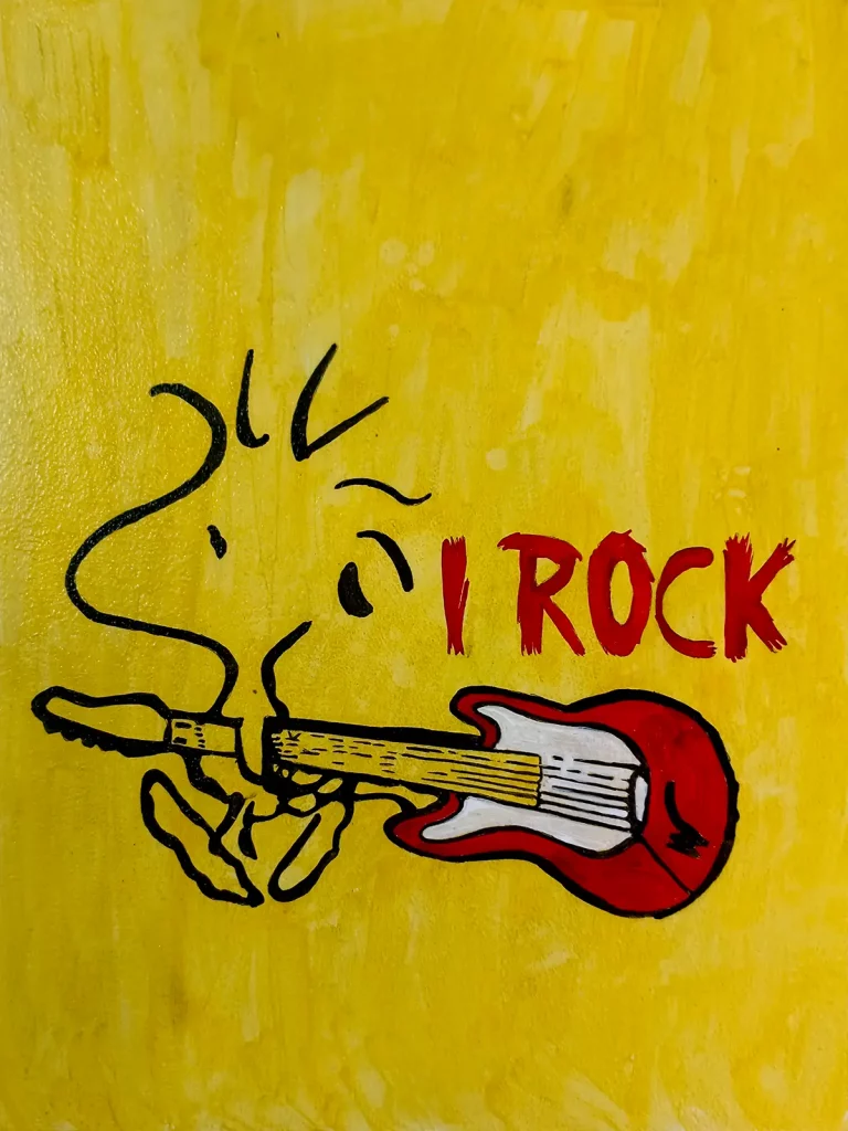 Snoopy tocando guitarra eléctrica roja con texto I ROCK fondo amarillo