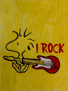 Snoopy tocando una guitarra eléctrica roja junto al mensaje I Rock
