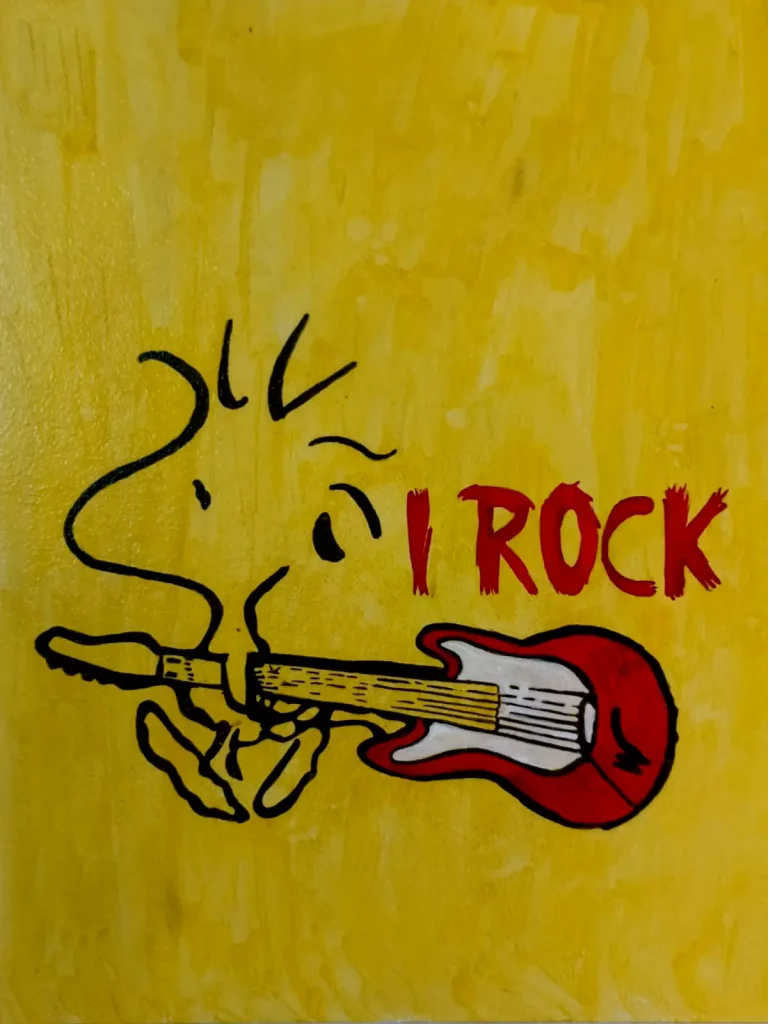 Snoopy tocando una guitarra eléctrica roja junto al mensaje I Rock